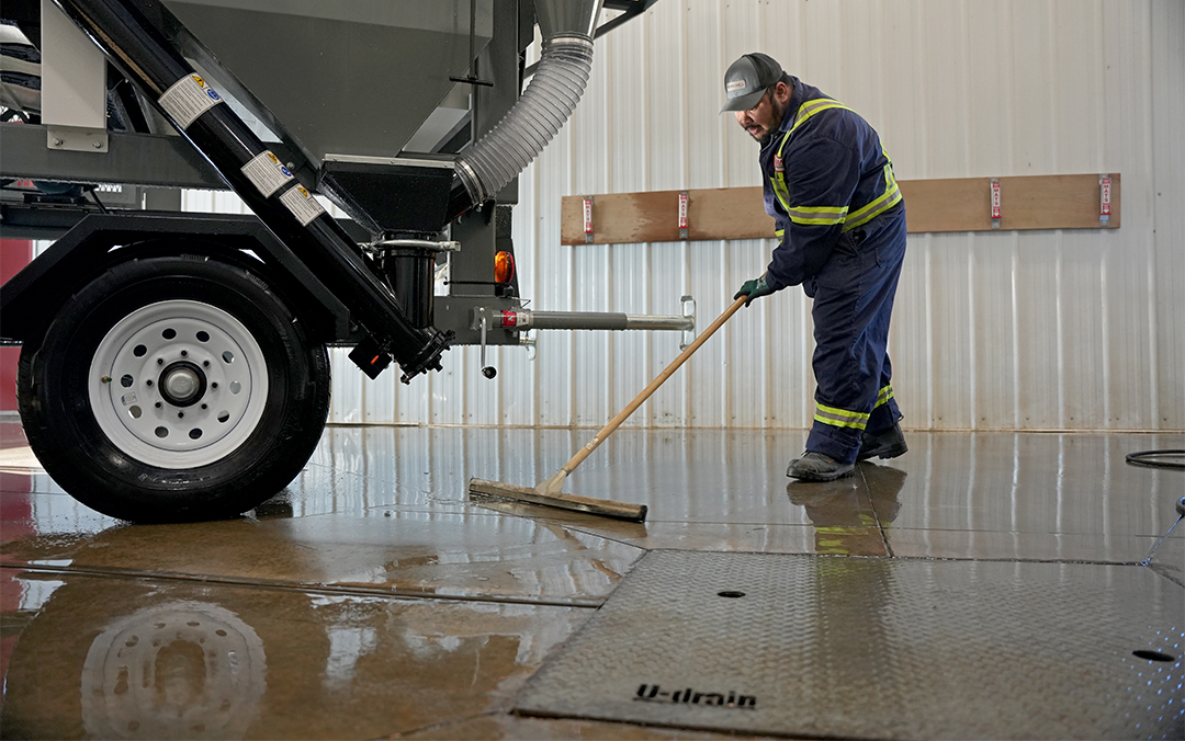 Man sweeping water into U-Drain slot